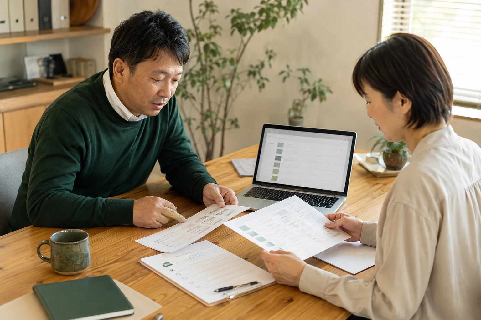 日本の中小企業担当者二人が記事一覧の資料とノートパソコンを見比べて棚卸しする様子