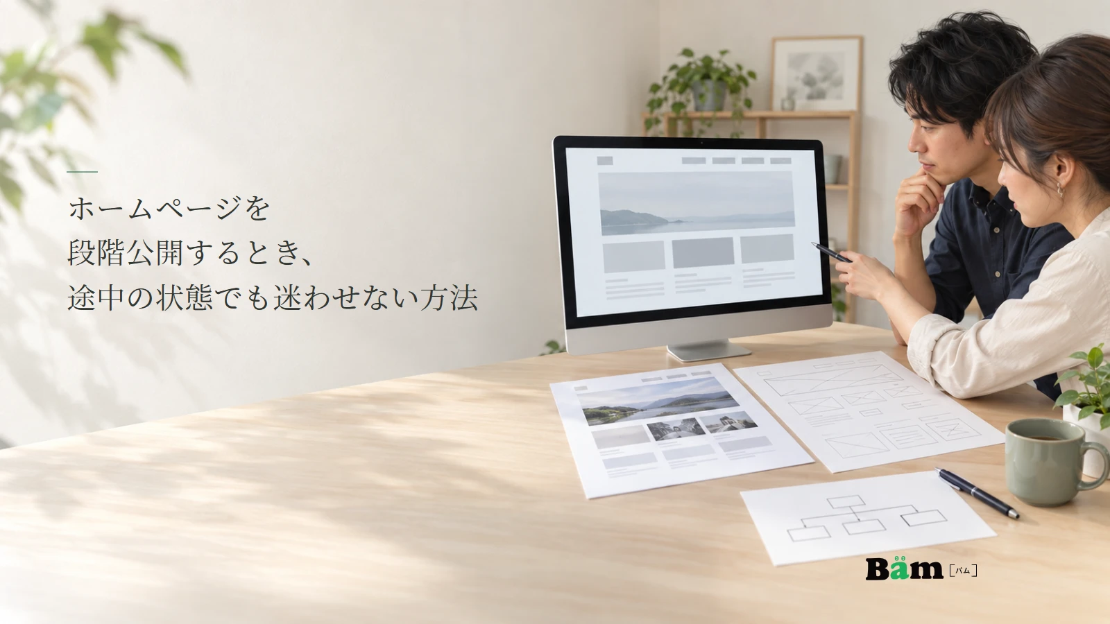 段階公開するホームページの画面案とページ構成を机上で確認する説明用写真。記事の全文タイトルと正式Bämロゴ。