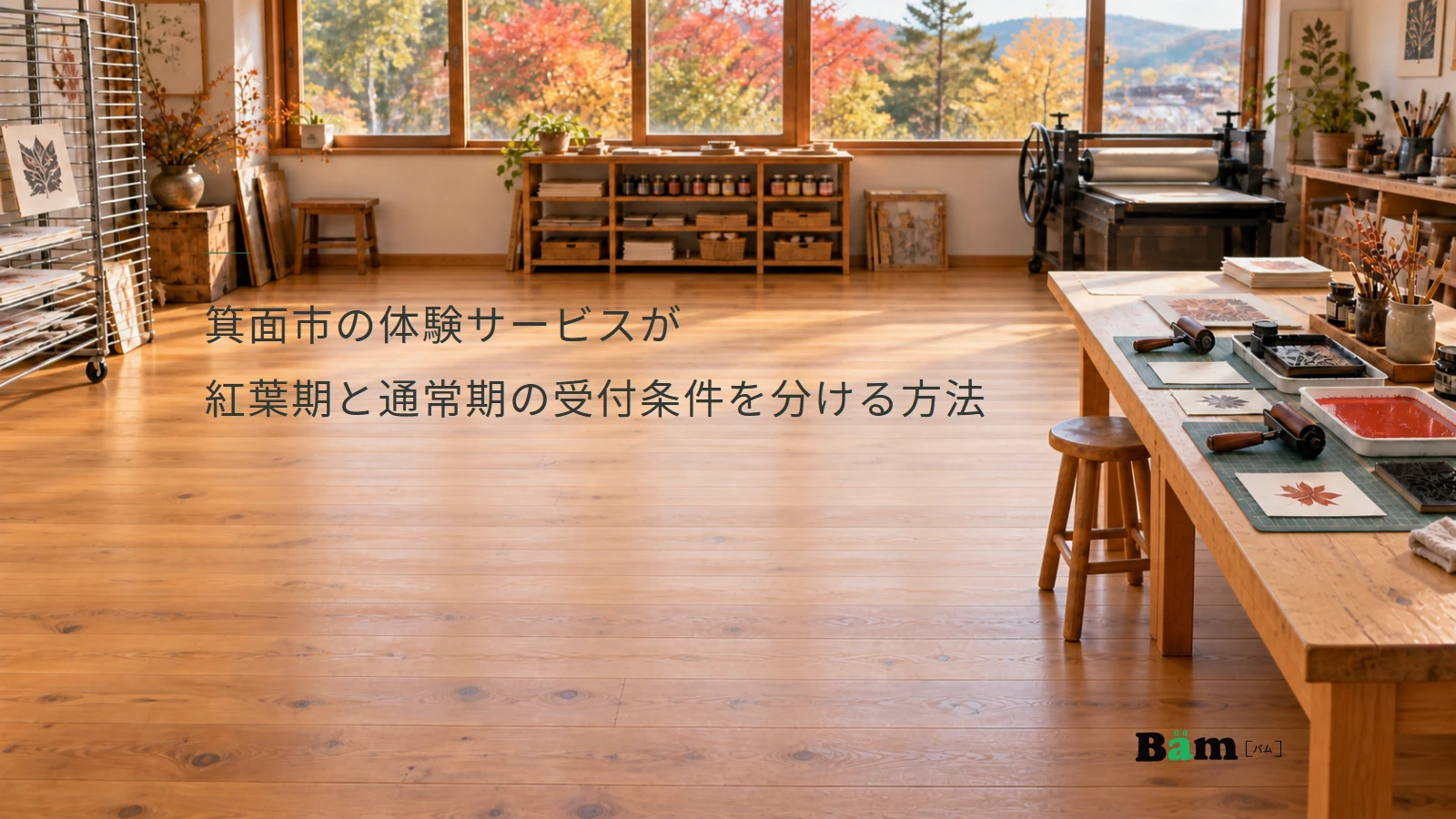 箕面市の体験サービスが紅葉期と通常期の受付条件を分ける方法というタイトル、版画の道具と作業台がある工房、窓の外に秋色の木々、右下にBämロゴ