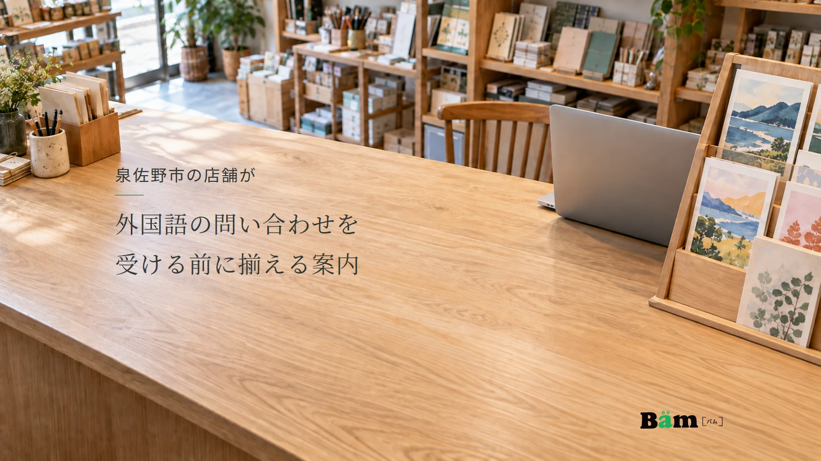 泉佐野市の店舗が外国語の問い合わせを受ける前に揃える案内というタイトル、文具店の商品棚と問い合わせ確認用のノートパソコンがある販売カウンター、右下にBämロゴ