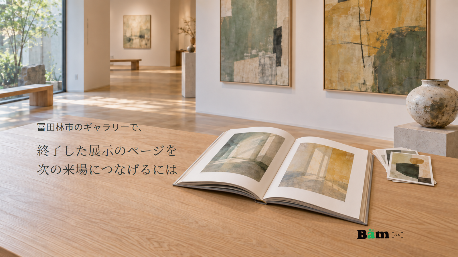 富田林市のギャラリーで、終了した展示のページを次の来場につなげるにはというタイトル、開いた展示図録と絵葉書、奥に抽象絵画と陶器が見えるギャラリー、右下にBämロゴ