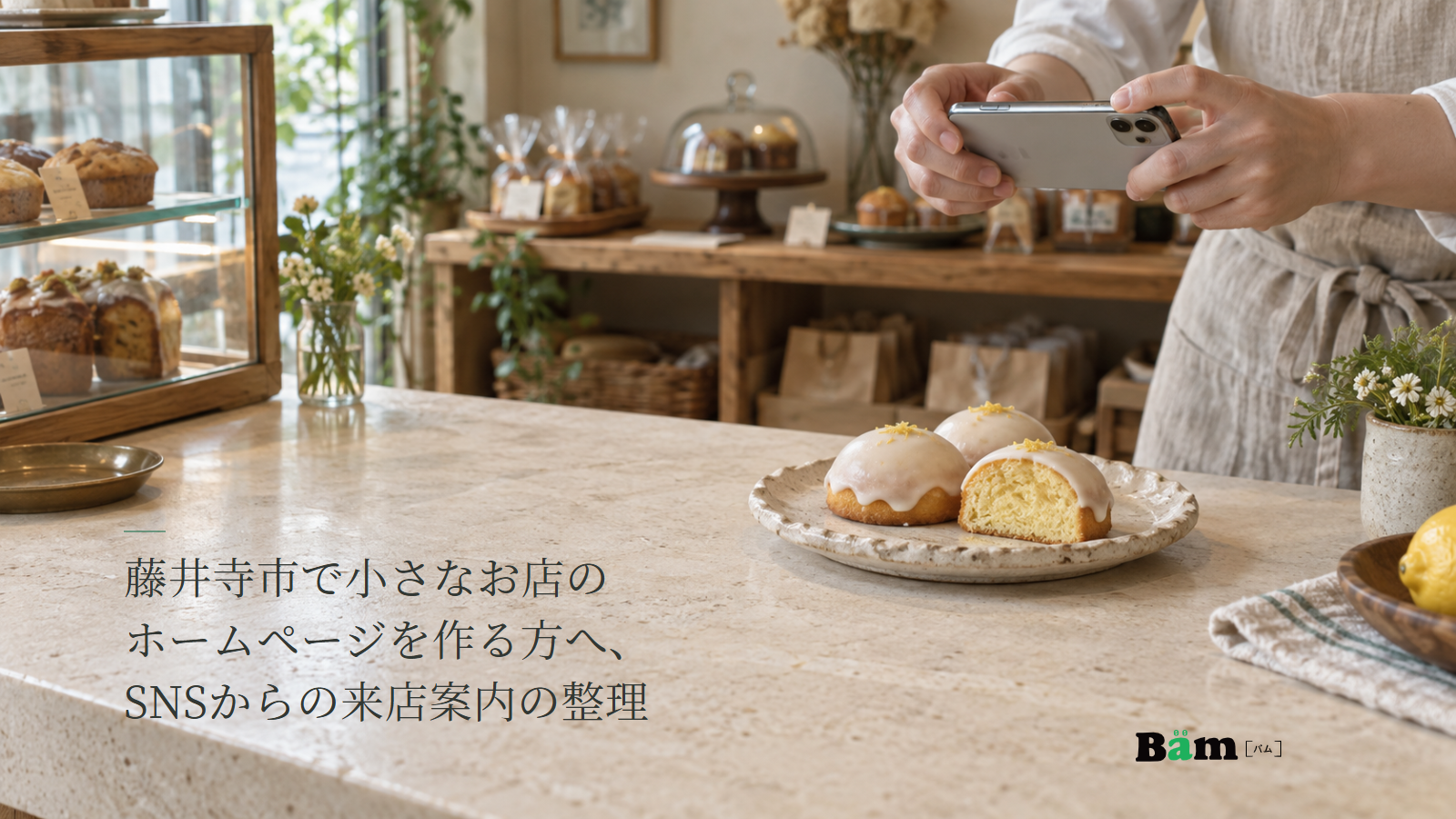 藤井寺市で小さなお店のホームページを作る方へ、SNSからの来店案内の整理という全文タイトル、白い糖衣のレモンケーキをスマートフォンで撮影する手元と焼き菓子店の店内、右下のBämロゴ