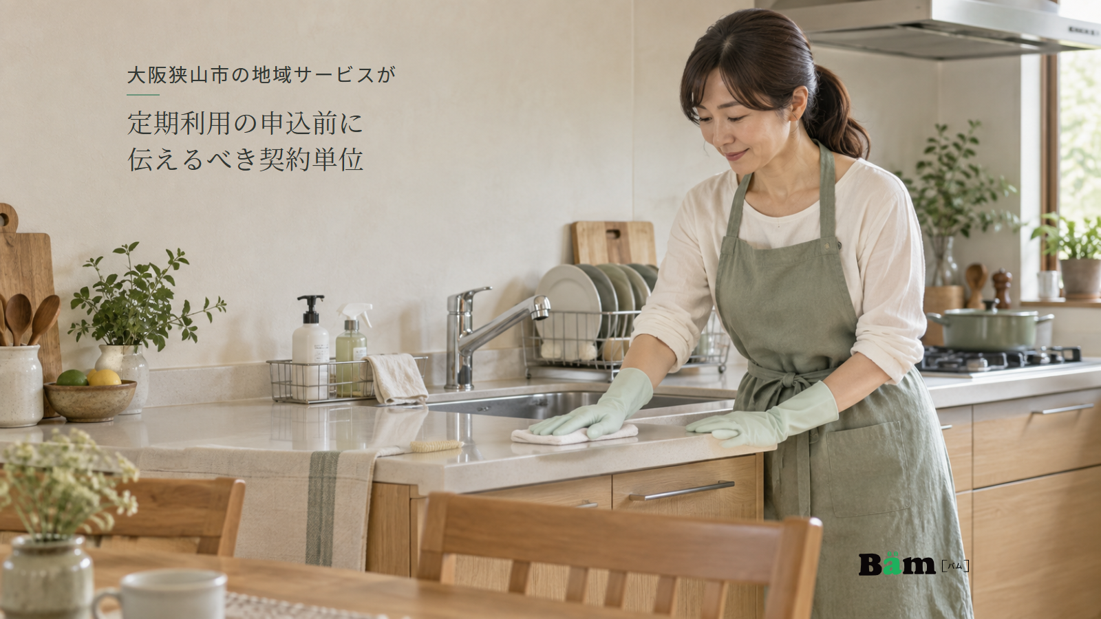 大阪狭山市の地域サービスが定期利用の申込前に伝えるべき契約単位という全文タイトル、住まいのキッチンで布を使い作業台を拭く女性、右下のBämロゴ