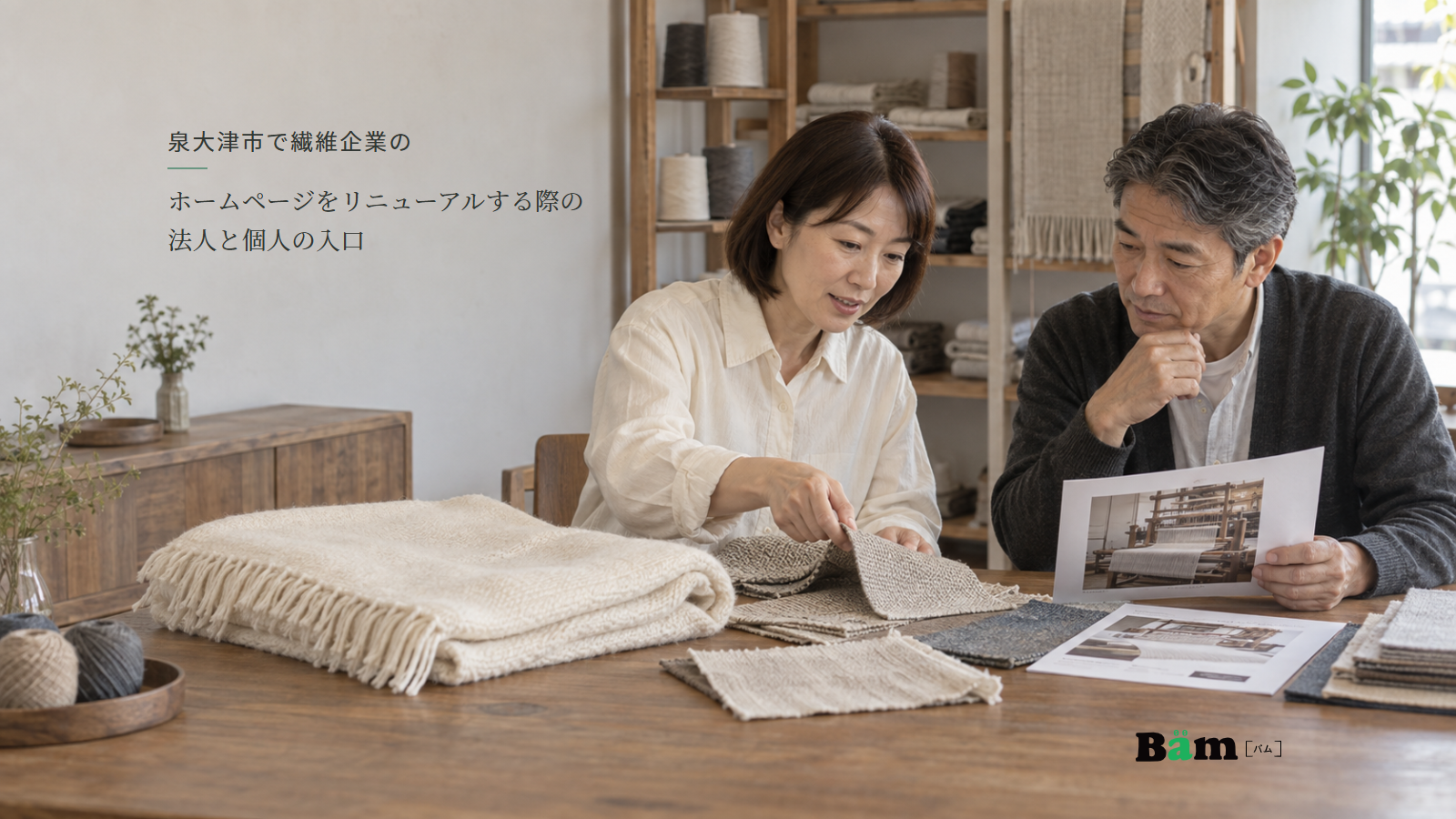 泉大津市で繊維企業のホームページをリニューアルする際の法人と個人の入口という全文タイトル、毛布や織り見本と工程写真を確認する二人の担当者、右下のBämロゴ