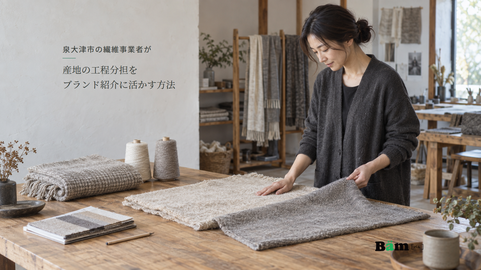 泉大津市の繊維事業者が産地の工程分担をブランド紹介に活かす方法という全文タイトル、ひざ掛けの仕上げ見本と糸を机に並べて確認する担当者、右下のBämロゴ