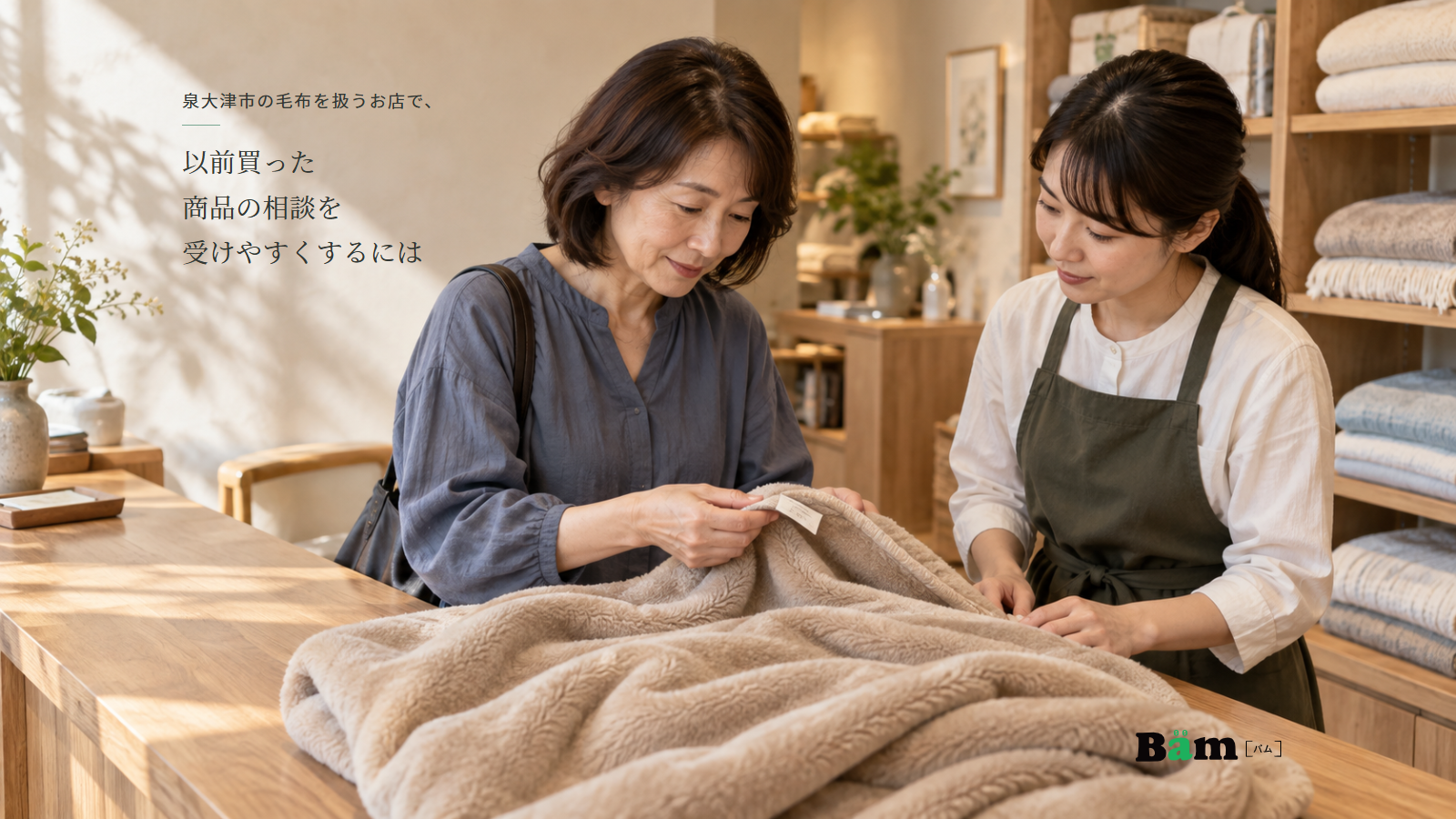 毛布の表示を確かめながら店頭で相談する二人と、泉大津市の毛布を扱うお店で、以前買った商品の相談を受けやすくするにはのタイトル、右下のBämロゴ