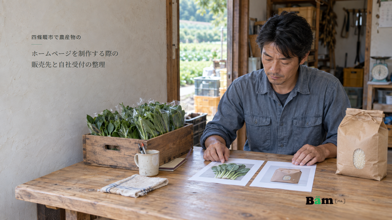 葉物野菜と袋入りの米を置いた作業机で商品資料を見比べる農園の担当者、四條畷市で農産物のホームページを制作する際の販売先と自社受付の整理の全文タイトル、右下のBämロゴ