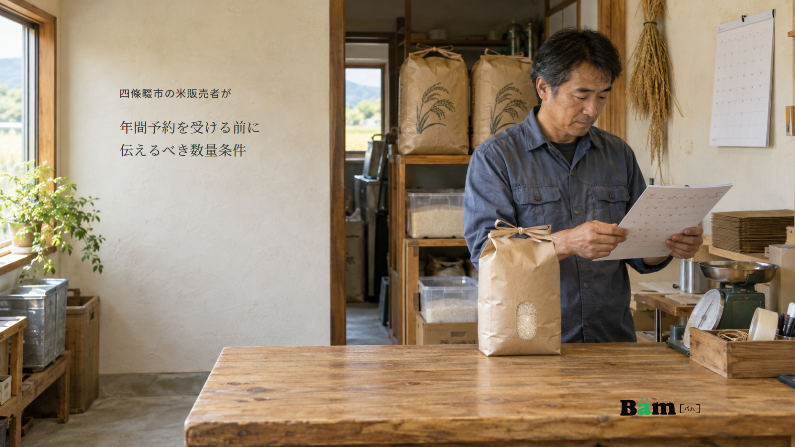米袋と計量器のある販売所で受渡しの予定表を確認する担当者、四條畷市の米販売者が年間予約を受ける前に伝えるべき数量条件の全文タイトル、右下のBämロゴ