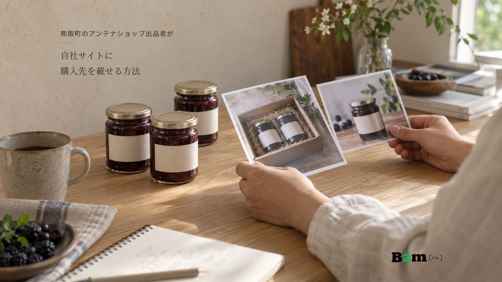 瓶入りジャムを置いた机で、ギフト箱と単品の掲載写真を手に取って比べる場面、熊取町のアンテナショップ出品者が自社サイトに購入先を載せる方法の全文タイトル、右下のBämロゴ