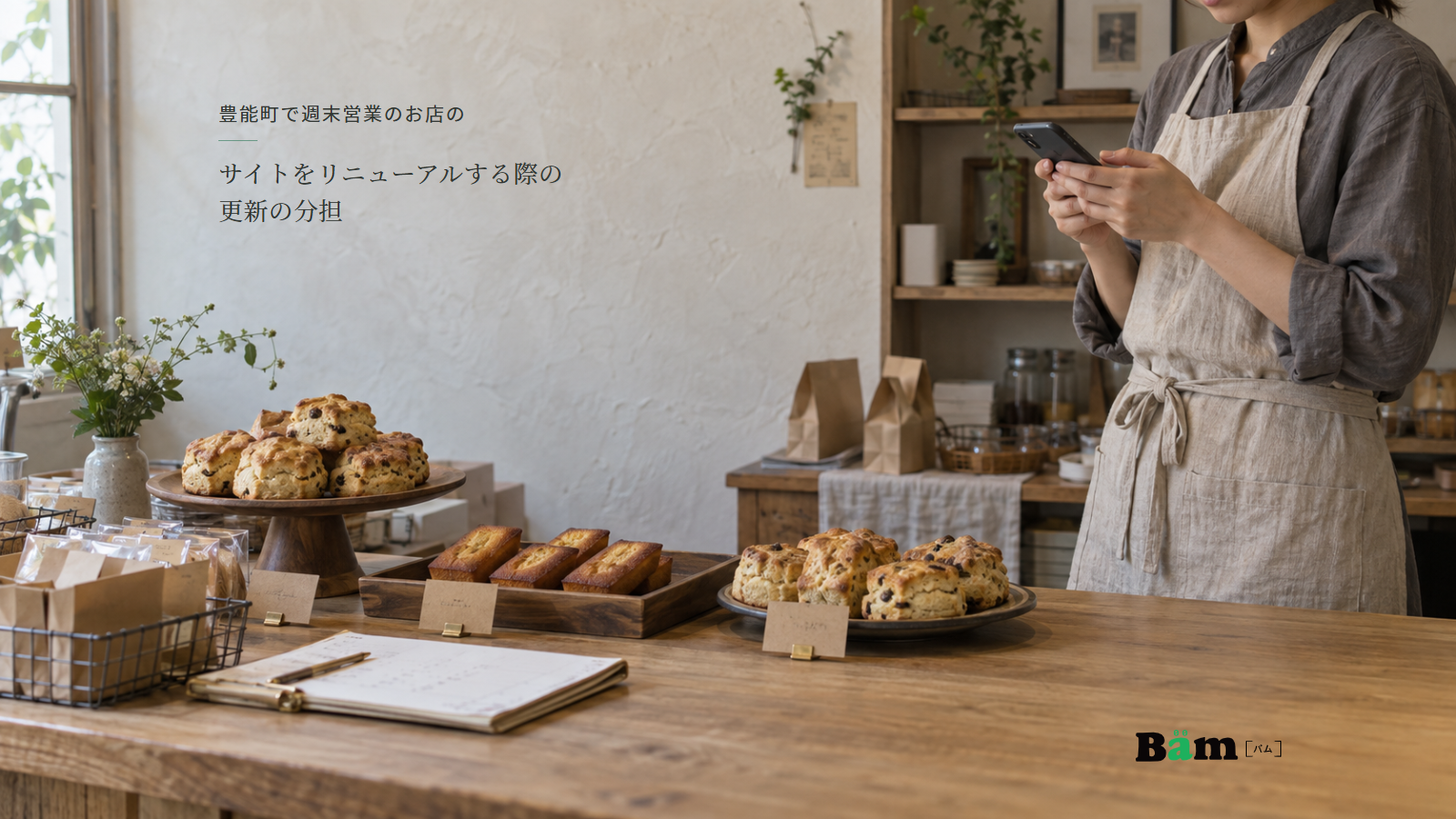 焼菓子と営業メモを置いたカウンターで販売担当がスマートフォンを確認する様子、豊能町で週末営業のお店のサイトをリニューアルする際の更新の分担の全文タイトル、右下のBämロゴ