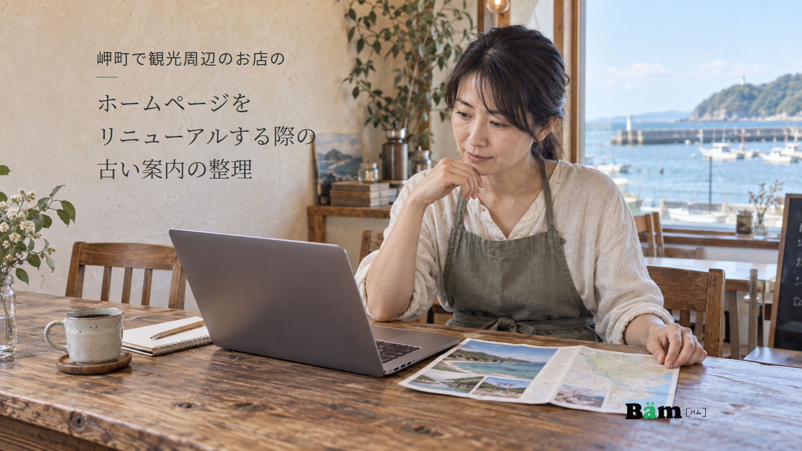 海辺のカフェの店主が机に広げた観光パンフレットとノートパソコンを見比べる場面、岬町で観光周辺のお店のホームページをリニューアルする際の古い案内の整理の全文タイトル、右下のBämロゴ