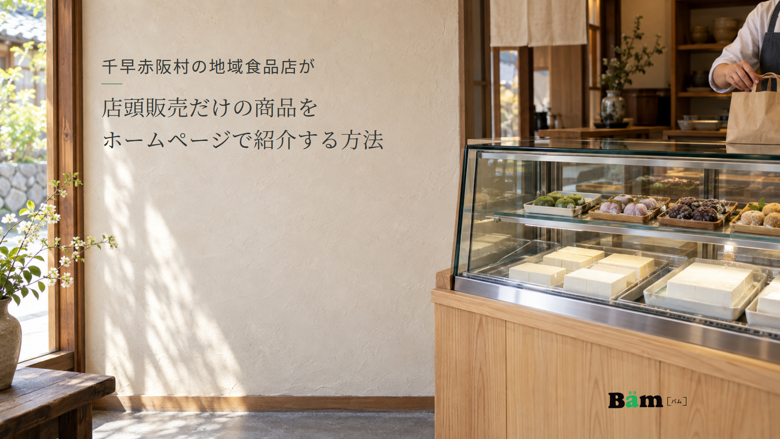 豆腐や菓子を店頭で選べる小さな食品店の販売ケース。千早赤阪村の地域食品店が店頭販売だけの商品をホームページで紹介する方法の全文タイトルと右下のBämロゴ