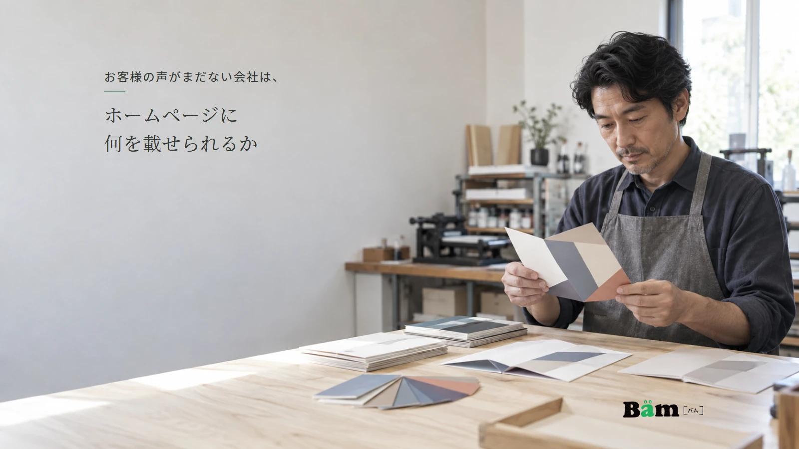印刷会社の担当者が自社制作の紙見本を確認する説明用イメージ写真。実在の顧客の声や納品事例ではない。全文タイトルと正式Bämロゴを配置。