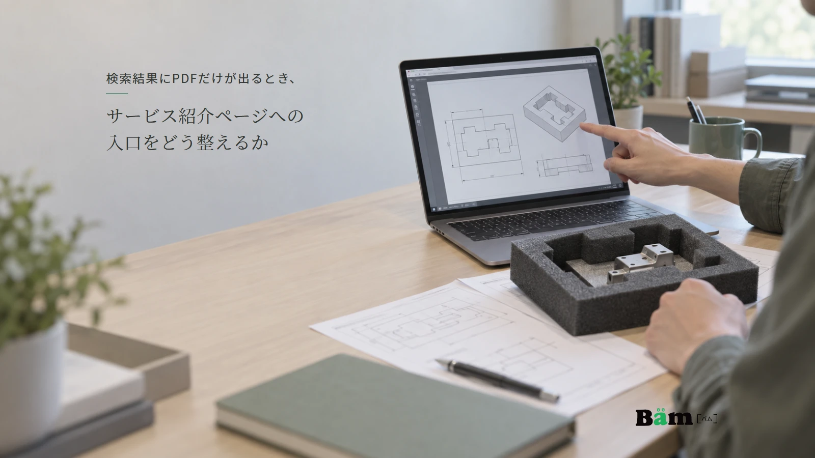 緩衝材の加工サンプルと、パソコンで開いた仕様資料を照らし合わせる場面。全文タイトルと正式Bämロゴを配置。