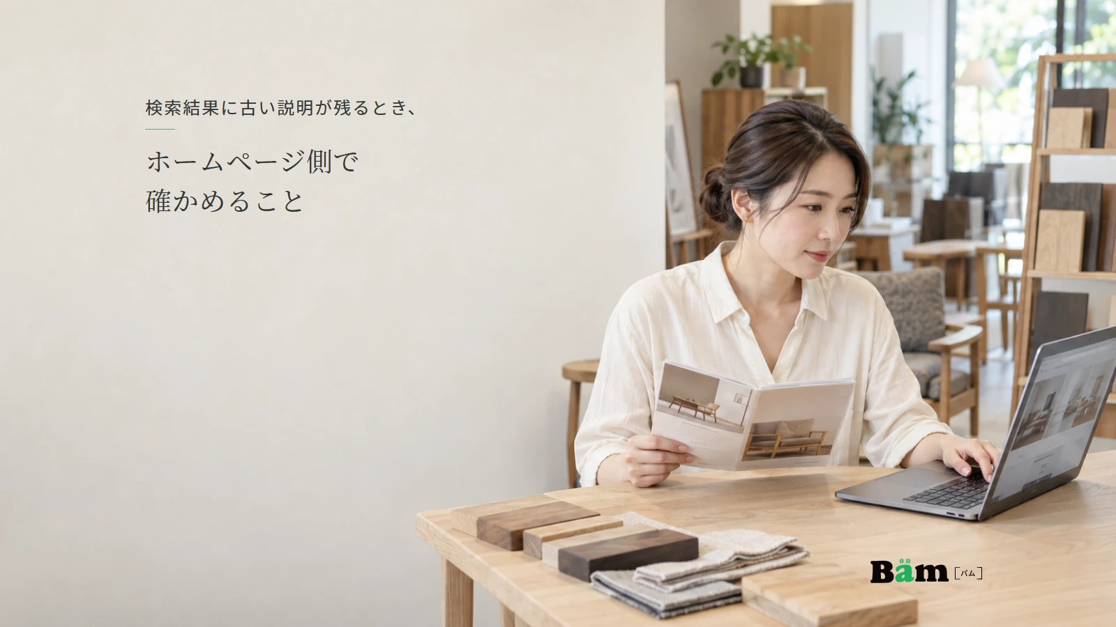 展示家具のあるショールームで公開ページと案内資料を確認する担当者のイメージ。全文タイトルと正式Bämロゴ。