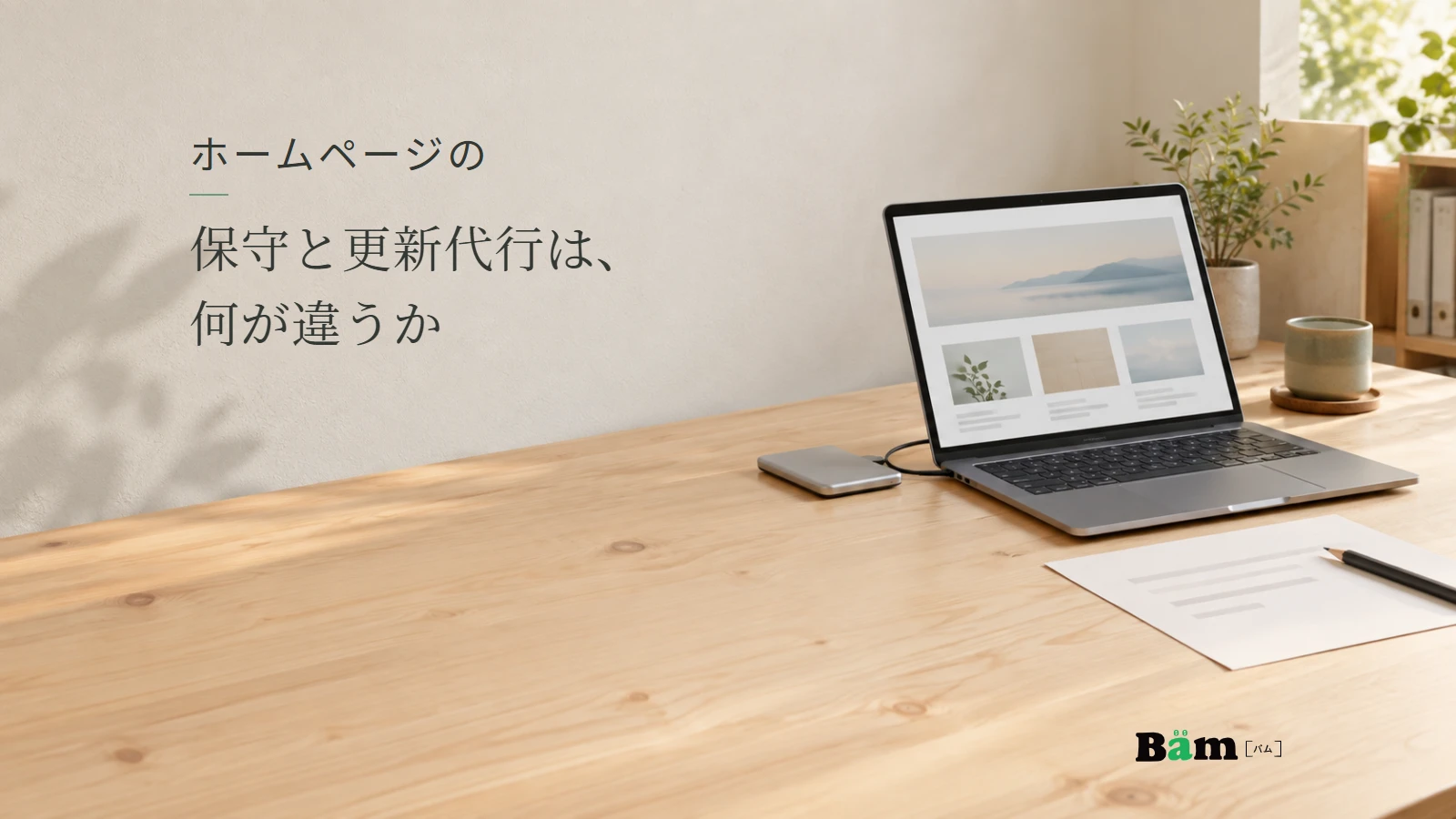 サイト画面のノートパソコンと修正用の紙、外付けドライブ。記事の全文タイトルと正式Bämロゴ。